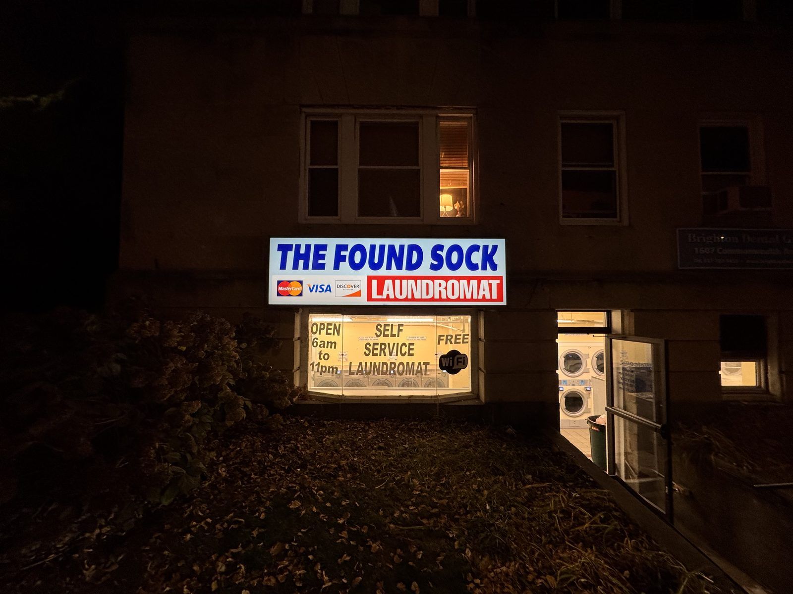 Night exterior — sign lit up, open until 11 PM